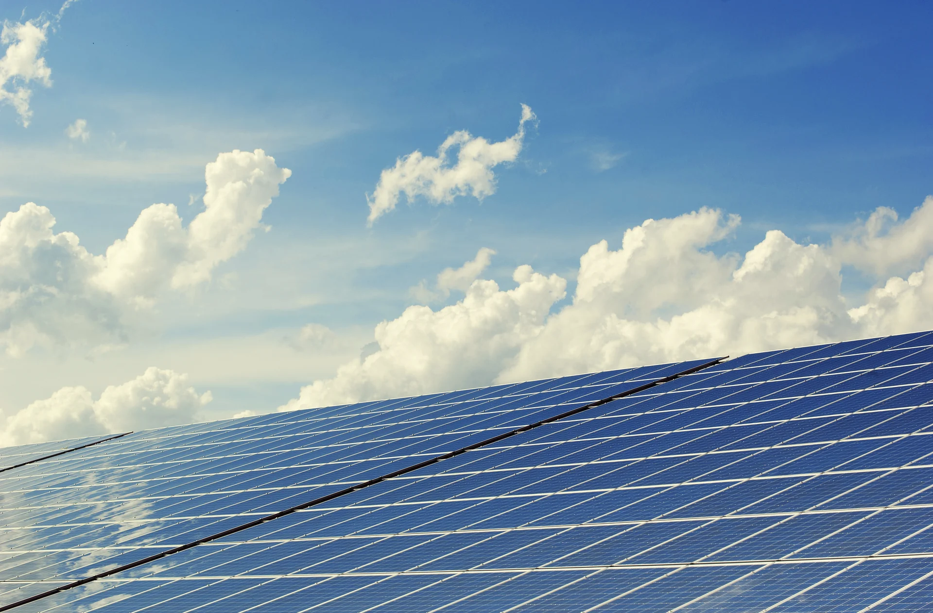Solar panels angled toward a bright blue sky